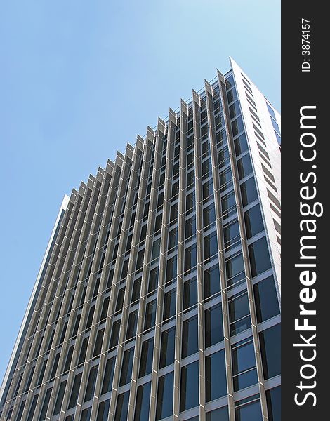 Tall black office building against a bright blue sky. Tall black office building against a bright blue sky