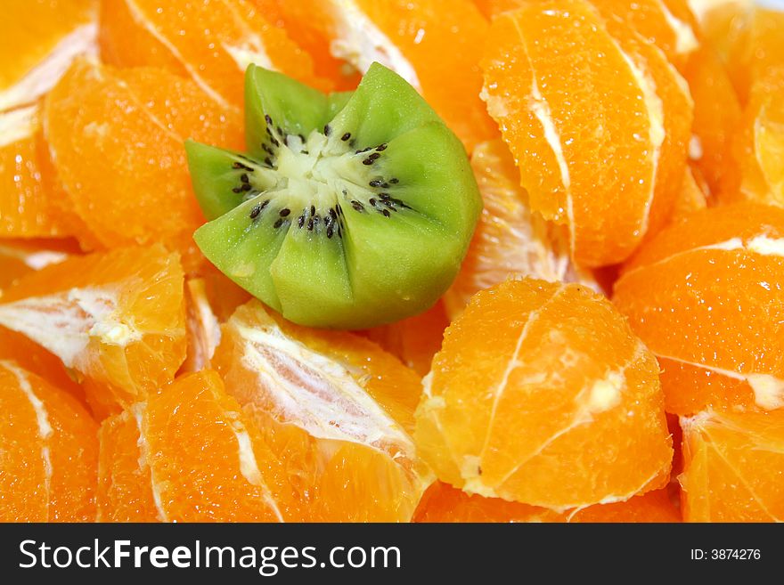 Several sliced oranges and one kiwi for background. Several sliced oranges and one kiwi for background