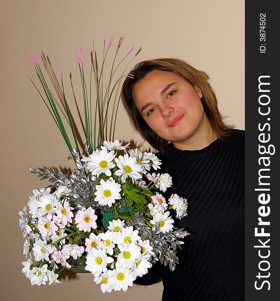 The lovely girl poses with a bouquet of flowers. The lovely girl poses with a bouquet of flowers