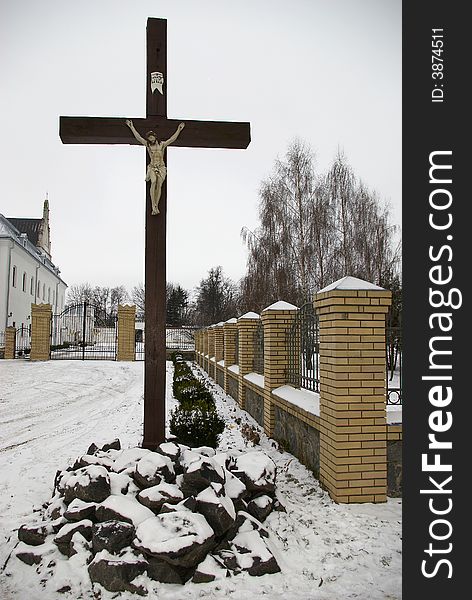 Wooden cross on road before a church. Wooden cross on road before a church