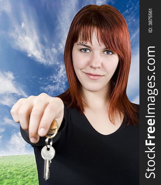 Cute smiling redhead girl holding keys towards the camera. Cute smiling redhead girl holding keys towards the camera.