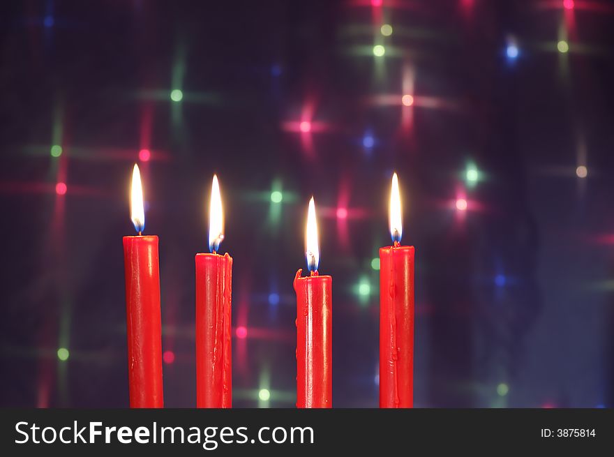 Four Christmas  red candles against glow backdrop. Four Christmas  red candles against glow backdrop