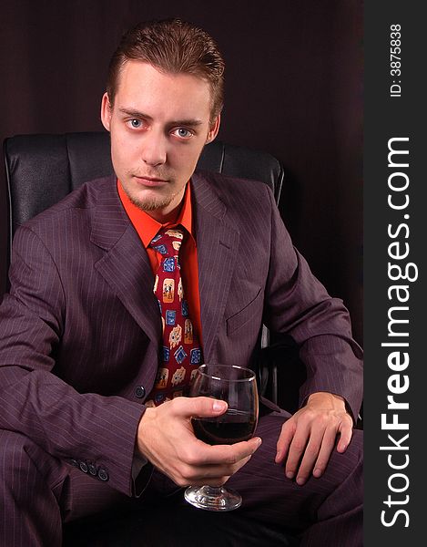 Young man in suit holding a glass