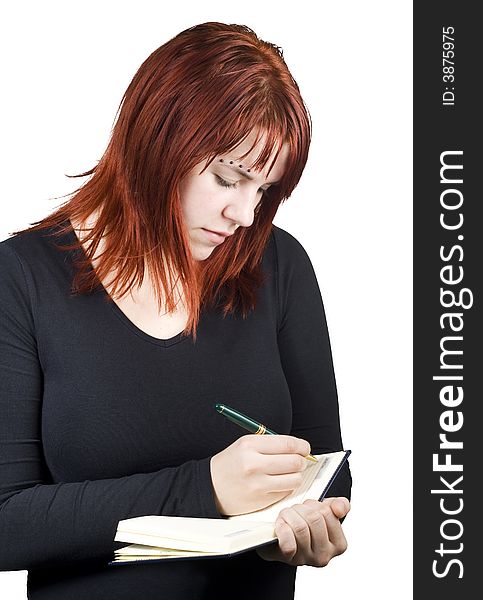 Cute girl with red hair writing in her diary or notebook with blank pages. Cute girl with red hair writing in her diary or notebook with blank pages.