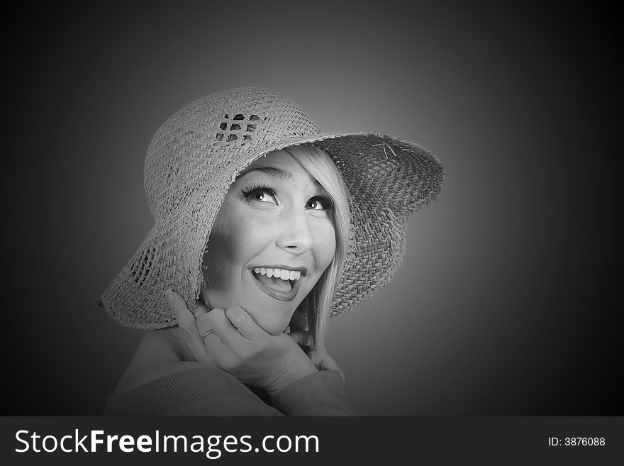 A blonde model with a straw hat smiling in black and white. A blonde model with a straw hat smiling in black and white