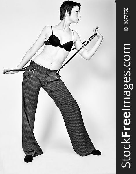 Studio fashion portrait of a young woman with short hair posing fashionably in bra and trousers. Studio fashion portrait of a young woman with short hair posing fashionably in bra and trousers