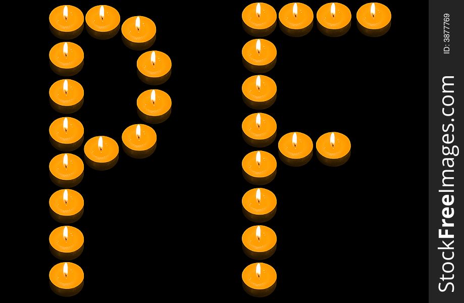 A group of burning candles forming PF on the black background. A group of burning candles forming PF on the black background