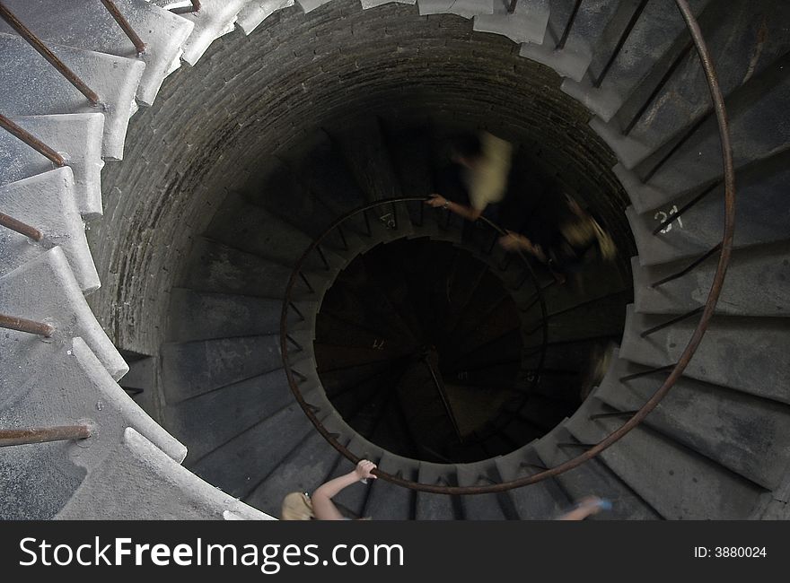 People quickly rise on a spiral staircase