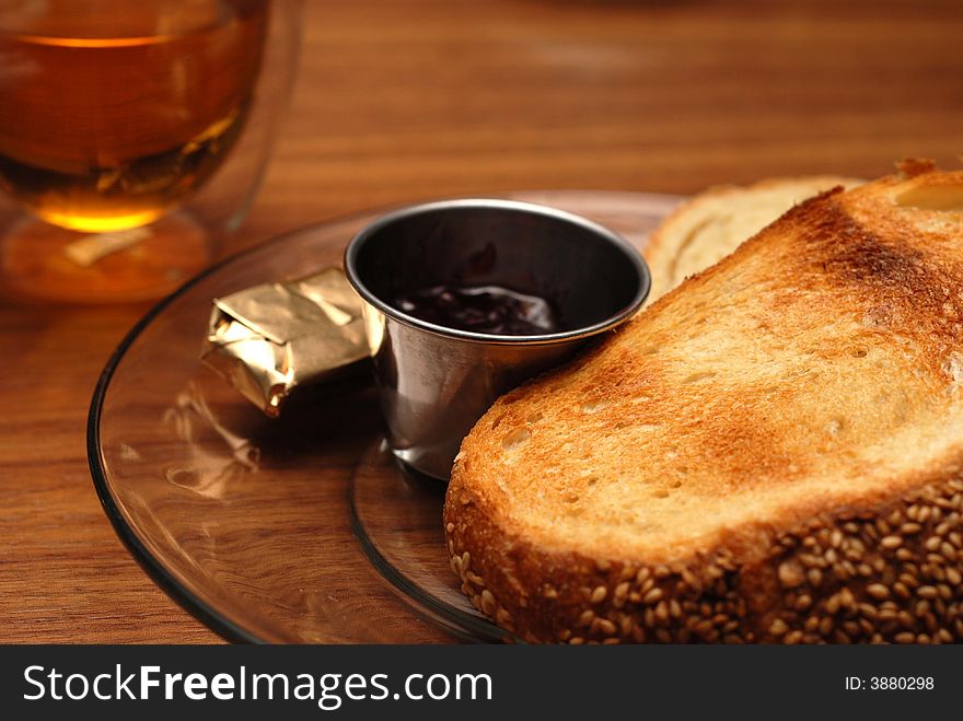 A plate of jam and toast with a cup of tea. A plate of jam and toast with a cup of tea