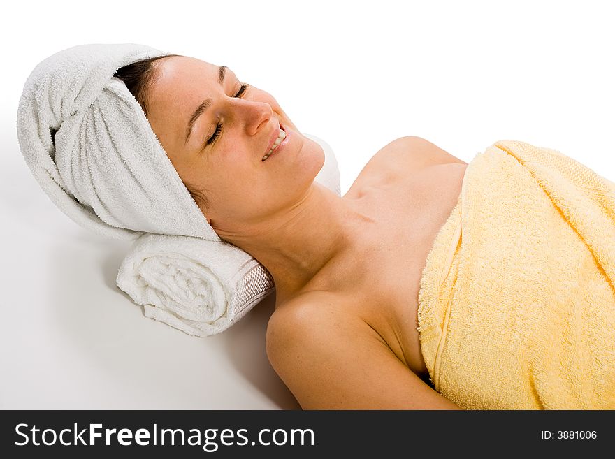 Woman from upper sideview. Lying on neck support, wrapped into bath towel. Woman from upper sideview. Lying on neck support, wrapped into bath towel