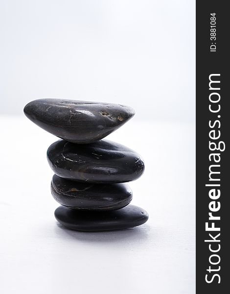 Four stapled, round, smooth black stones. Zen-Style. White background. Reassuring. Four stapled, round, smooth black stones. Zen-Style. White background. Reassuring.