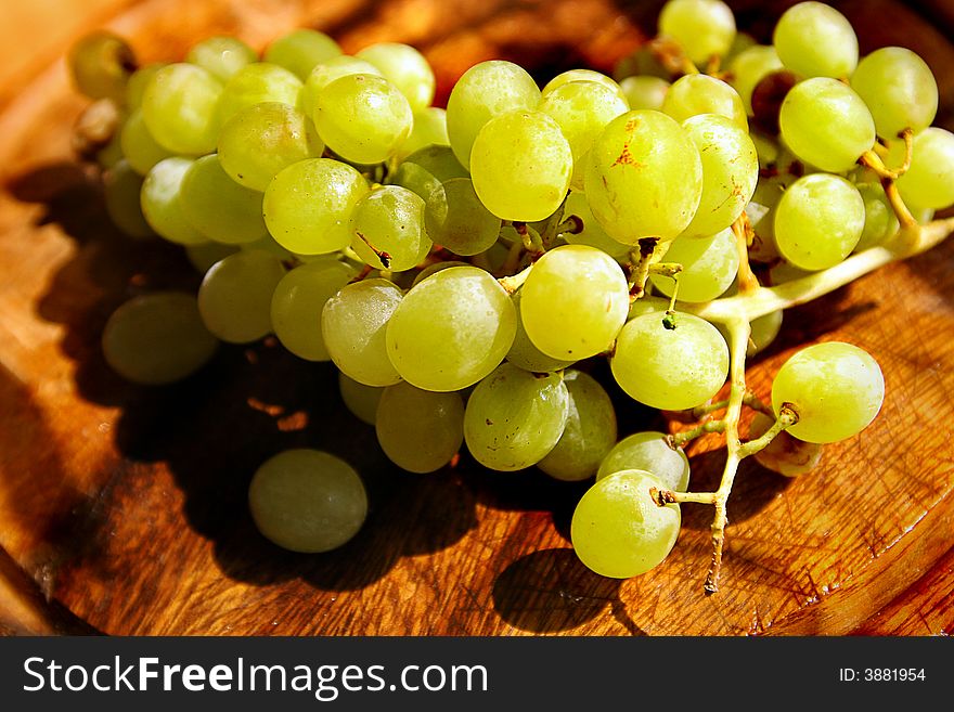 Green grapes on wood under the sun