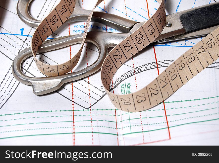 Still life of scissors, sewing pattern and tape-line. Still life of scissors, sewing pattern and tape-line