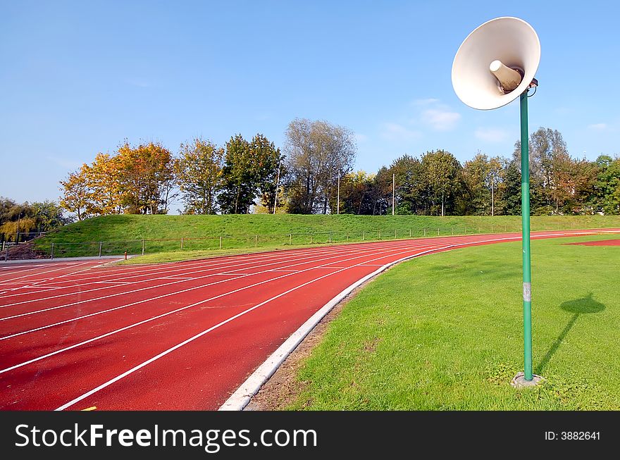 Racetrack for runners and a speaker in the grass. Racetrack for runners and a speaker in the grass