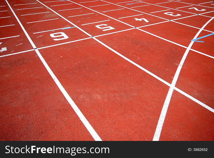 Numbers of a racetrack, on red tarmac, for runners. Numbers of a racetrack, on red tarmac, for runners