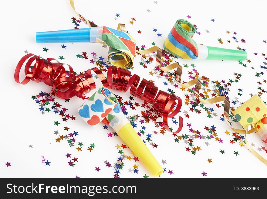 Small colorful confetti stars red and golden ribbons and four colorful party blowers on white background. Small colorful confetti stars red and golden ribbons and four colorful party blowers on white background