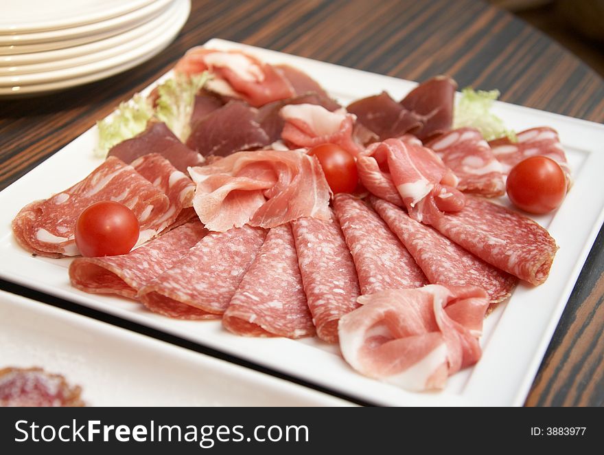 The white square plate with different meat bits. The white square plate with different meat bits