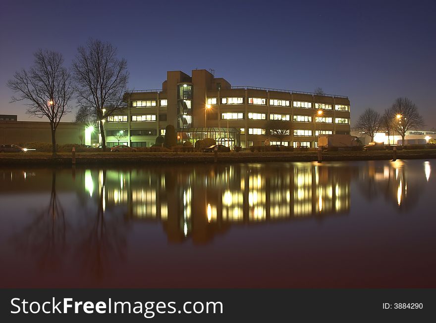 Office building at night, reflecting in water