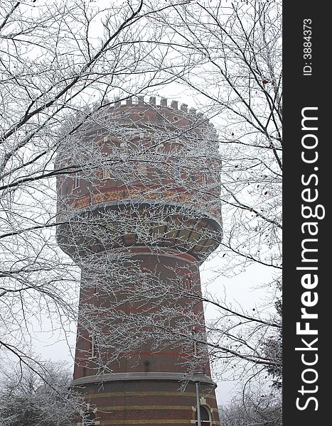 Water pressure tower made of red brick surrounded by winter trees. Water pressure tower made of red brick surrounded by winter trees