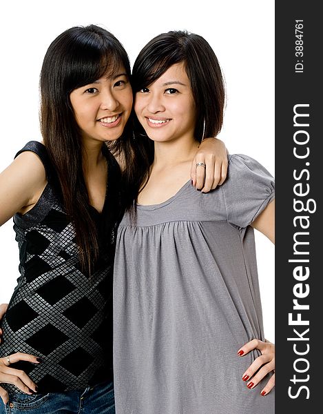 Two young Asian women standing together on white background. Two young Asian women standing together on white background