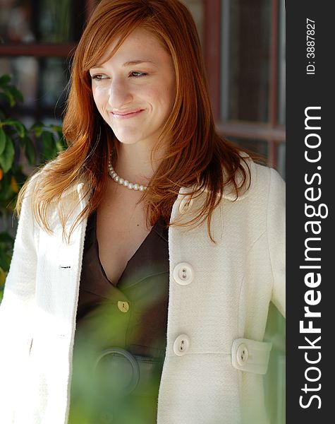 Attractive woman with red hair wearing overcoat