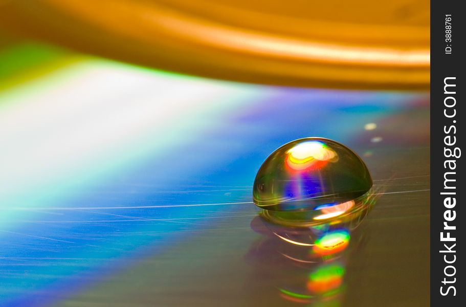 Water drop on old CD plate, interested interference colours. Visible scratches. Water drop on old CD plate, interested interference colours. Visible scratches.