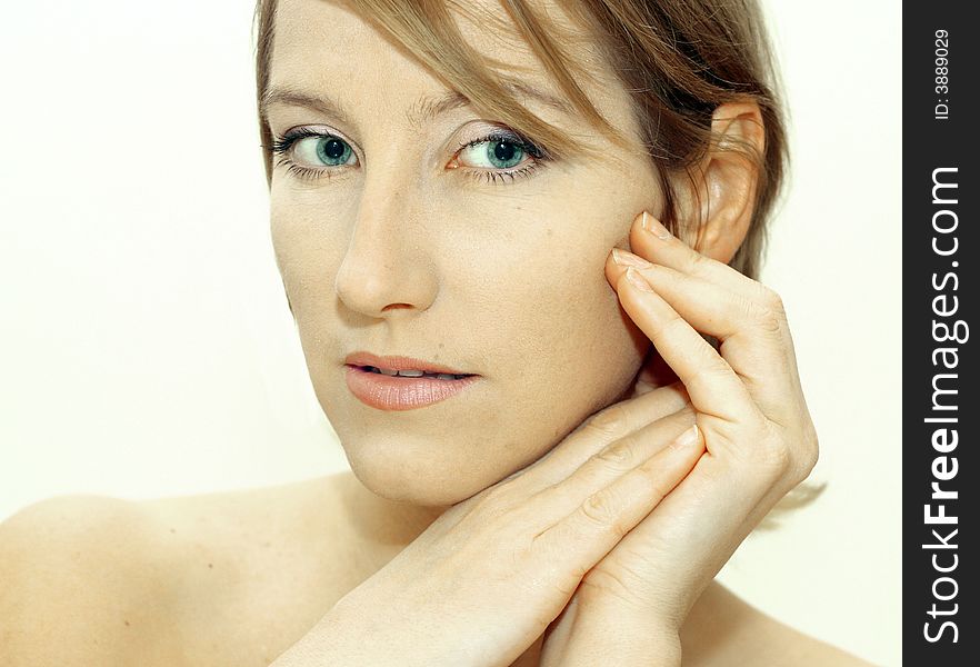 Attractive young woman with hands framing face. White background. Attractive young woman with hands framing face. White background.