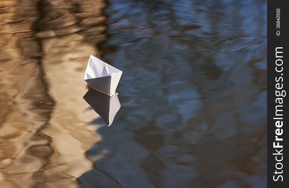 Paper boat floating in the creek closeup
