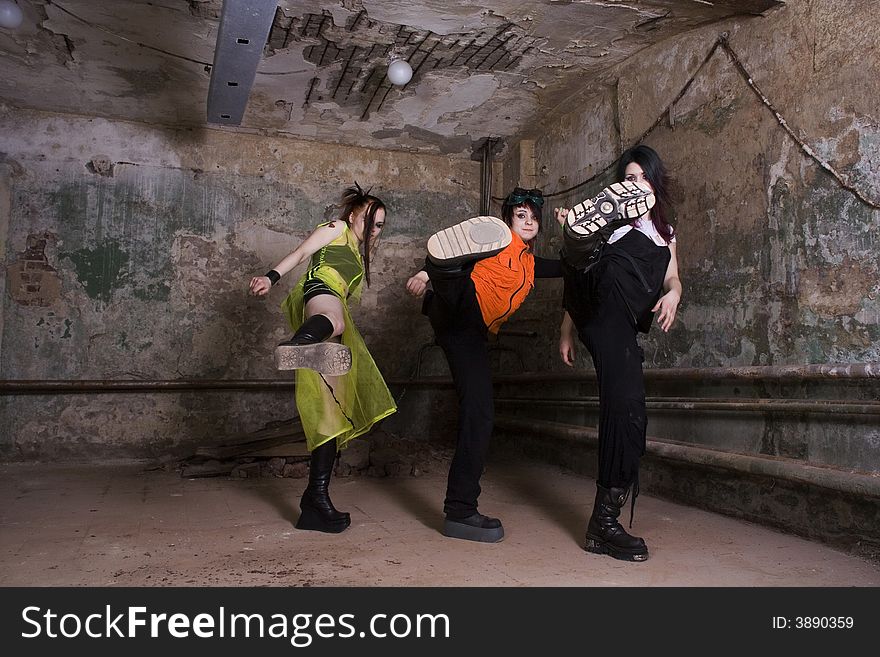 Aggressive girls of goth in a gloomy dirty cellar