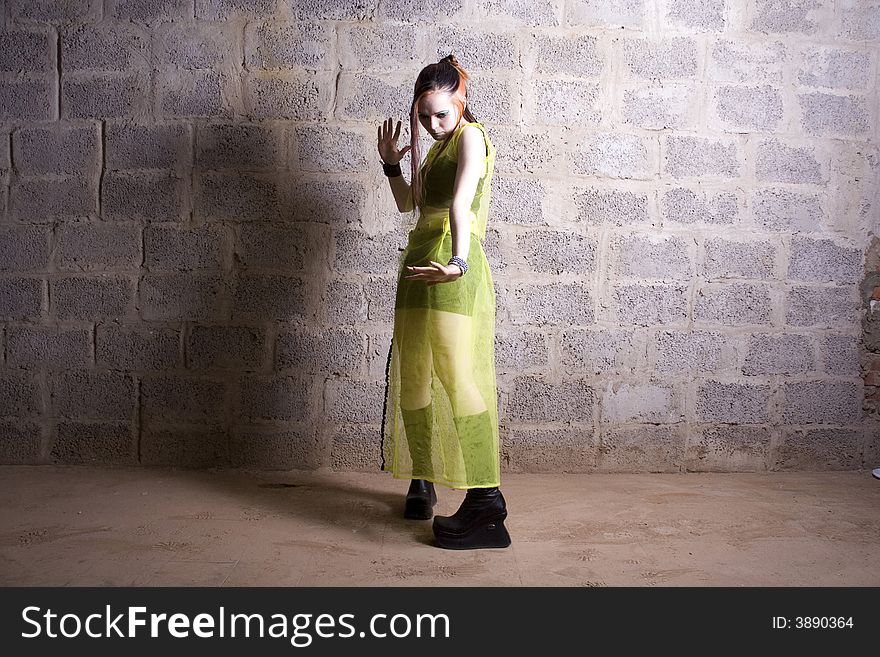 The girl in gothic style make-up on a background of a stone wall