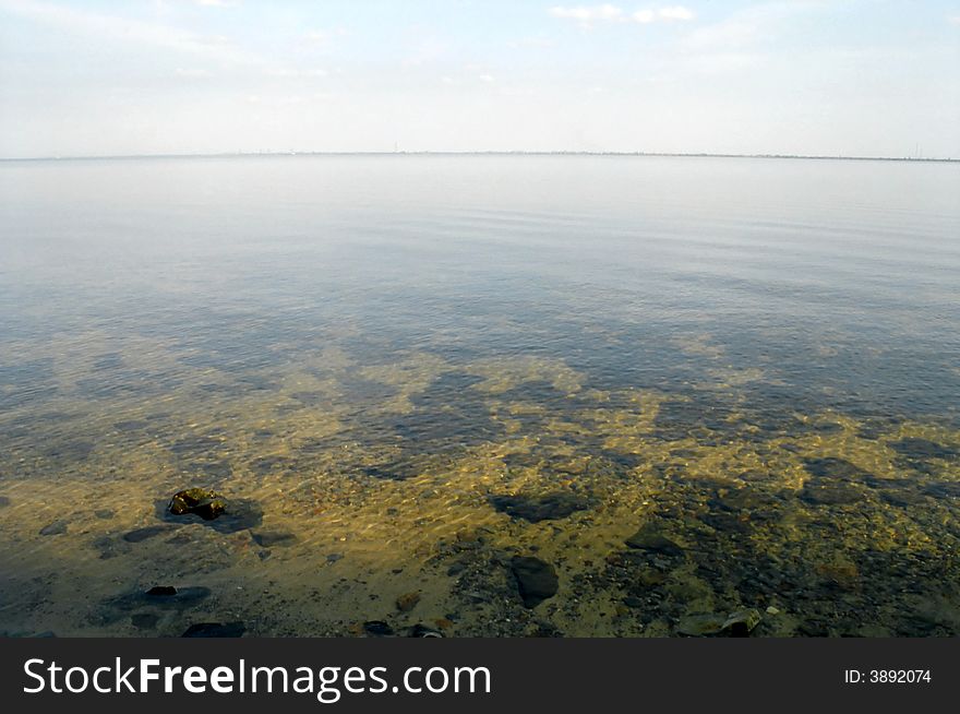 The quiet sea early in the morning. Through water the bottom is visible. The quiet sea early in the morning. Through water the bottom is visible.