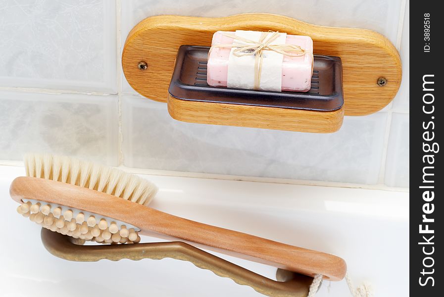 Relaxing spa scene with exfoliating brush massager and pink handmade soap in plastic soap dish. Relaxing spa scene with exfoliating brush massager and pink handmade soap in plastic soap dish