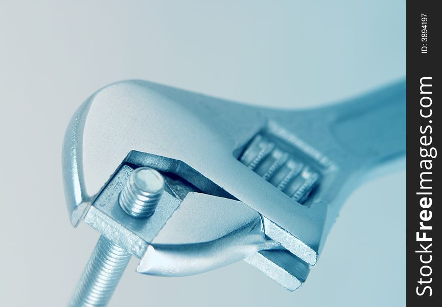 Close-up of adjustable spanner gripping a nut and bold