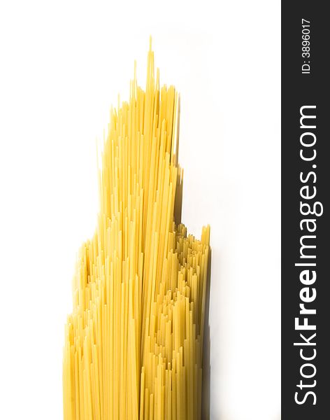 Uncooked spaghetti isolated over white background photographed, skyscraper shape. Uncooked spaghetti isolated over white background photographed, skyscraper shape