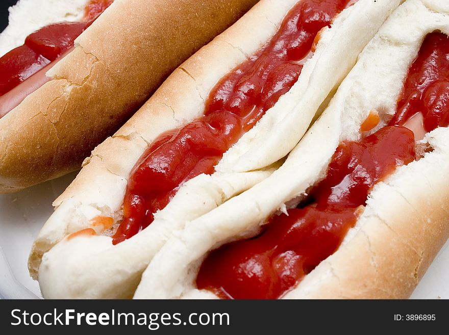 Three long saucy sausage white bun rolls. Three long saucy sausage white bun rolls