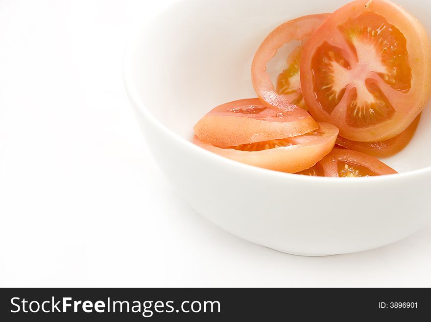 Fresh red tomato in small white ceramic bowl - white background. Fresh red tomato in small white ceramic bowl - white background