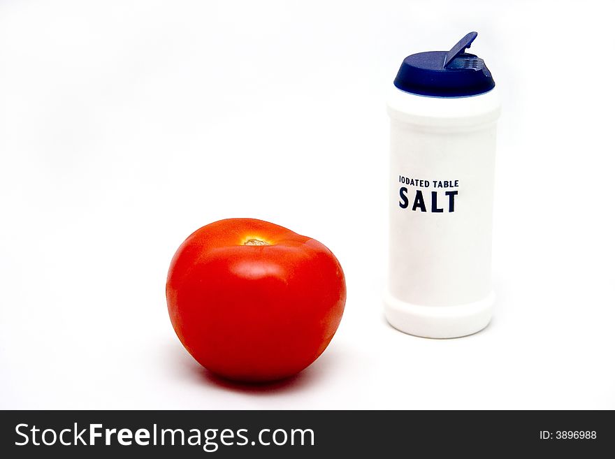 Fresh red tomato with white iodated table salt. Fresh red tomato with white iodated table salt