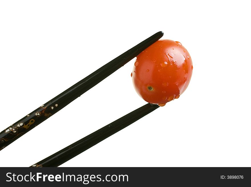 Grape Tomato held with black inlaid chopsticks. Grape Tomato held with black inlaid chopsticks
