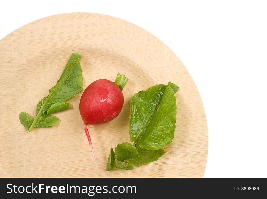 Radish and leaves on an environmentally friendly bamboo plate. Radish and leaves on an environmentally friendly bamboo plate