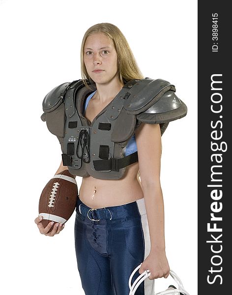 Female football player in shoulder pads holding football. Female football player in shoulder pads holding football.