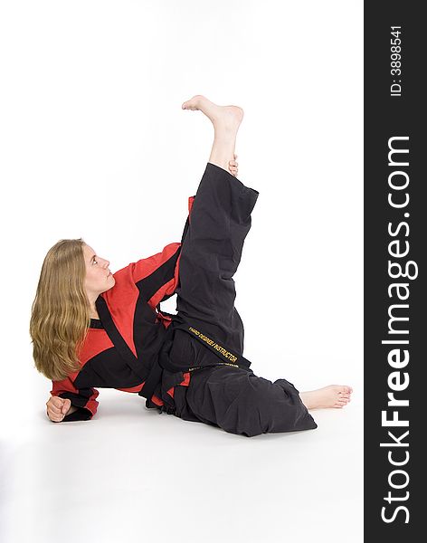 Female martial artist in red and black uniform stretching. Female martial artist in red and black uniform stretching.