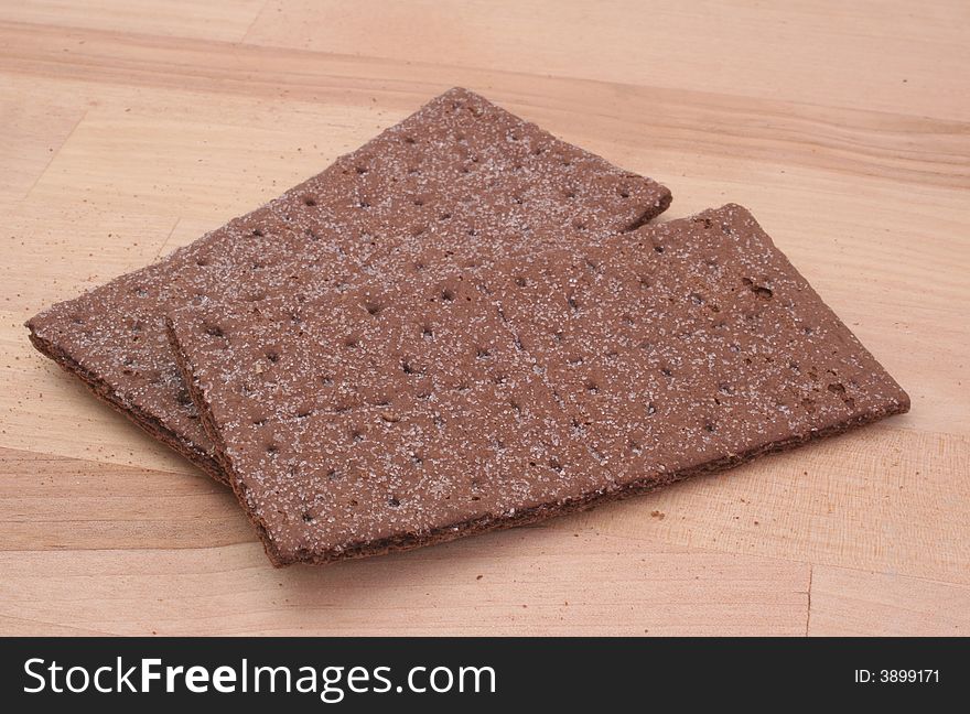 Chocolate Graham Crackers on Wooden Table with Crumbs