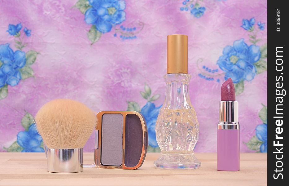 Cosmetics and Perfume on Vanity With Floral Background