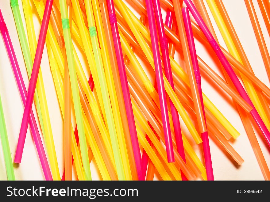 Random green, yellow and purple straws on white background. Random green, yellow and purple straws on white background