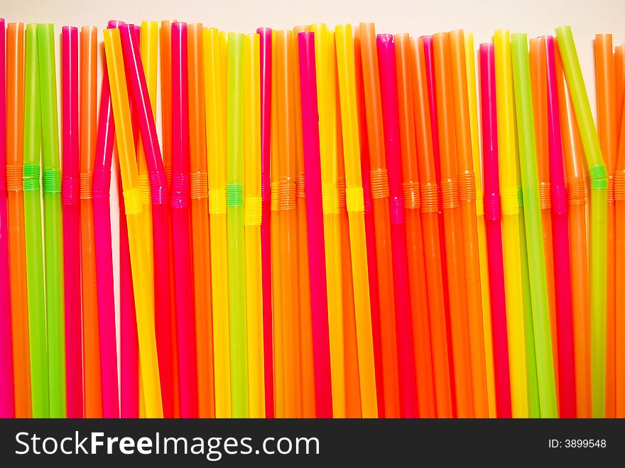 Random green, orange, yellow and purple straws on white background. Random green, orange, yellow and purple straws on white background