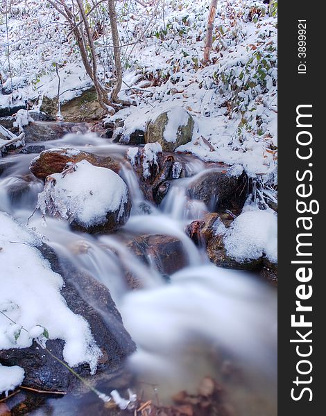 Mountain frozen torrent, winter season, vertical orientation. Mountain frozen torrent, winter season, vertical orientation