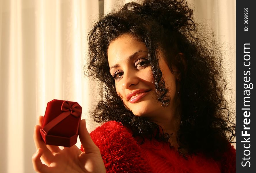 A woman dressed in red holding a giftbox. A woman dressed in red holding a giftbox