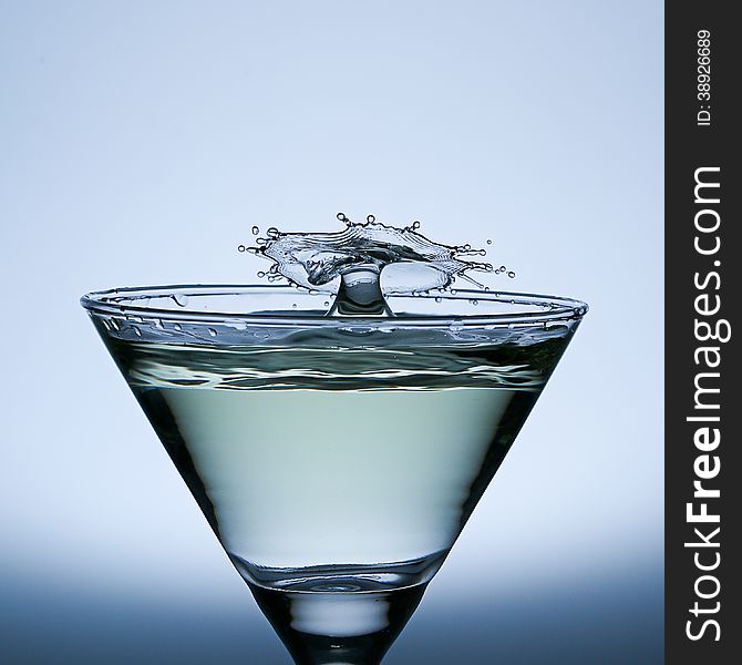 Water Drop Splash on the Champagne glass,splash water isolated on a gray background. Water Drop Splash on the Champagne glass,splash water isolated on a gray background.