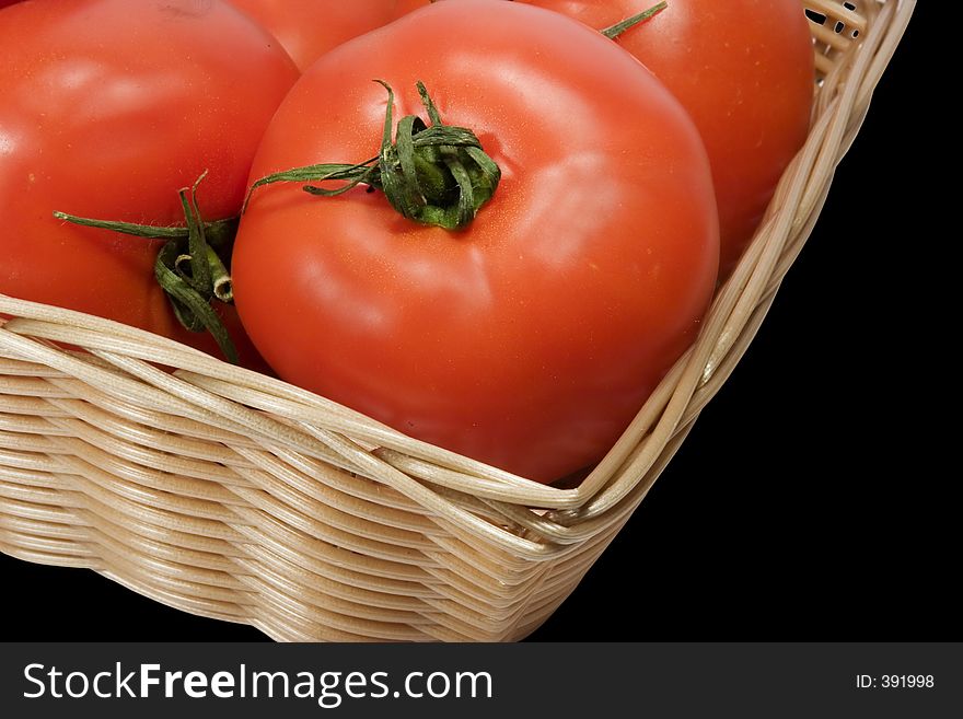 Basket with tomatoes on black background with clipping path