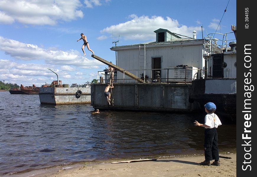 Children are diving into the river from the landing-stage